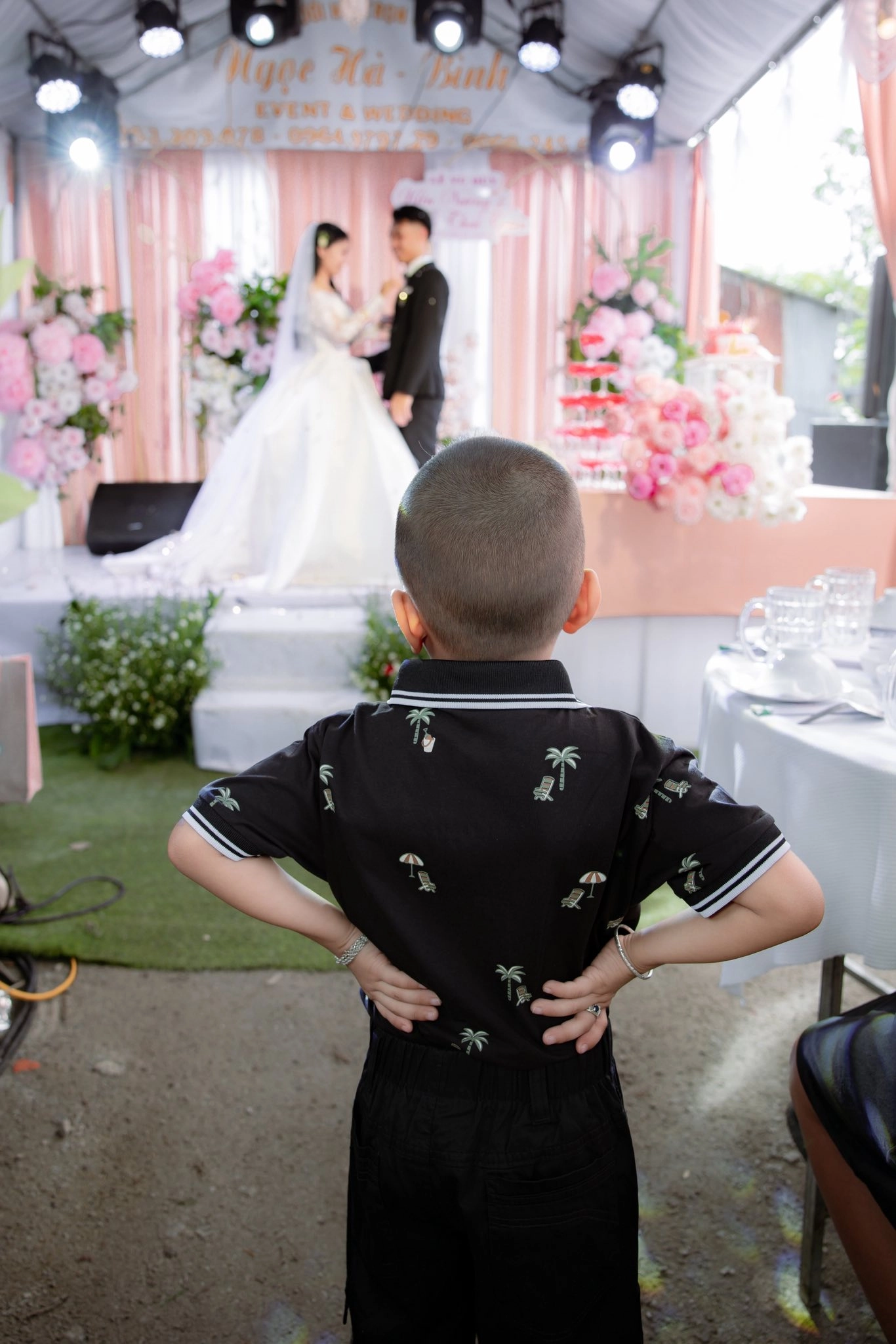 Thằng nhóc chống nạnh nhìn dâu rể